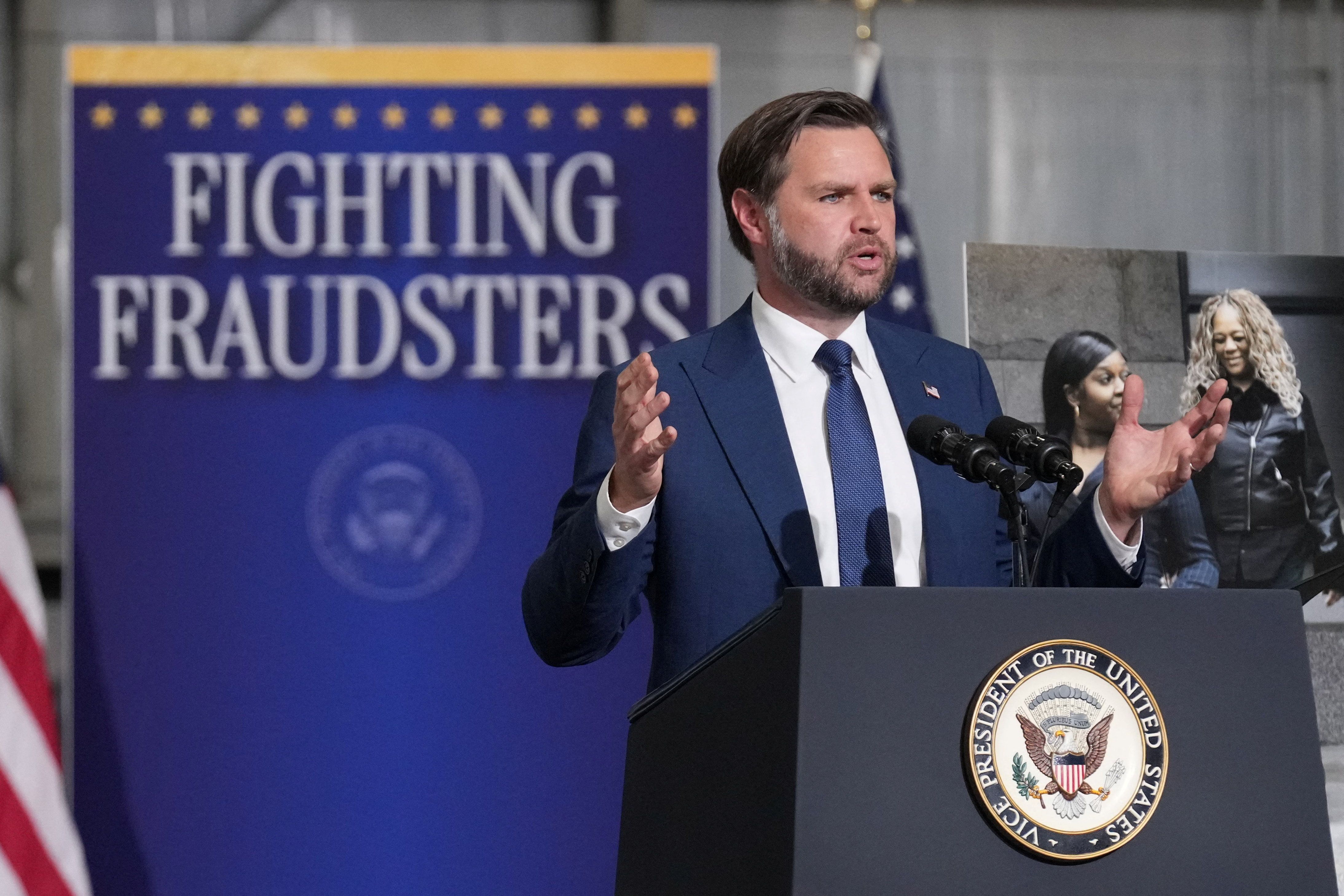 JD Vance and a sign that says FIGHTING FRAUDSTERS 