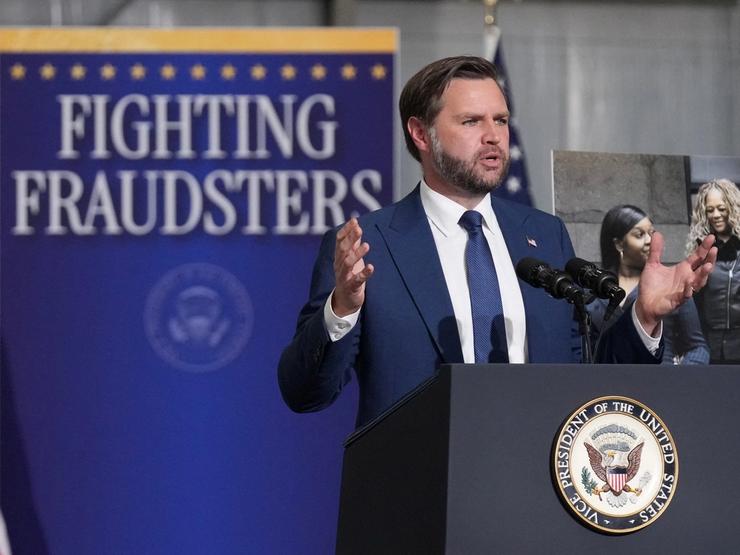 JD Vance and a sign that says FIGHTING FRAUDSTERS