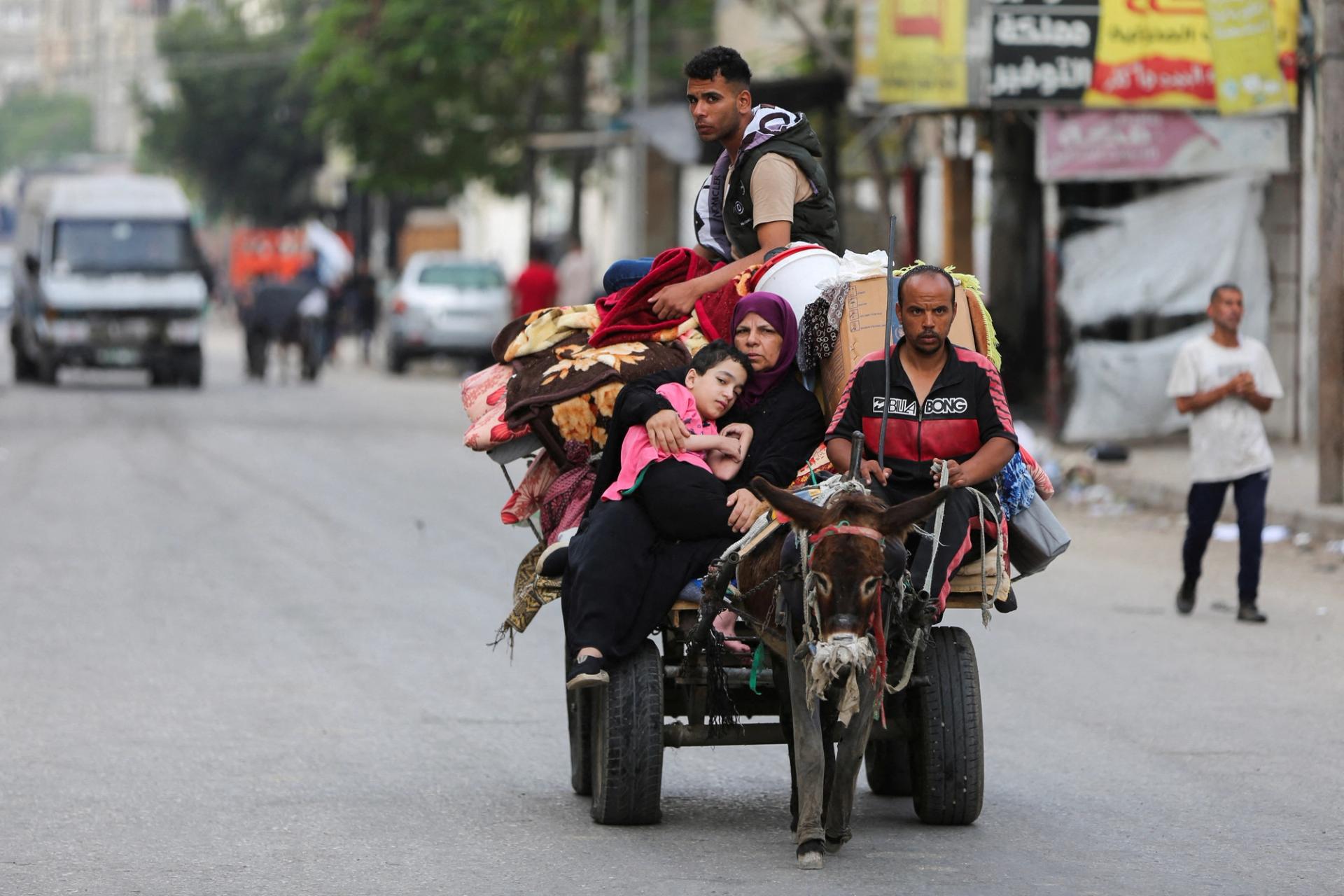 Palestinians travel in a donkey-drawn cart loaded with their belongings as they flee Rafah due to an Israeli military operation, in Rafah, in the southern Gaza Strip, May 28, 2024. REUTERS/Hatem Khaled 