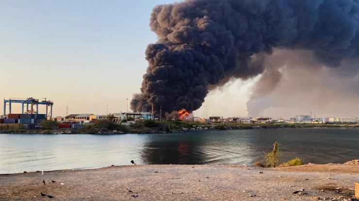 A view shows a large plume of smoke and fire rising from fuel depot in Port Sudan.