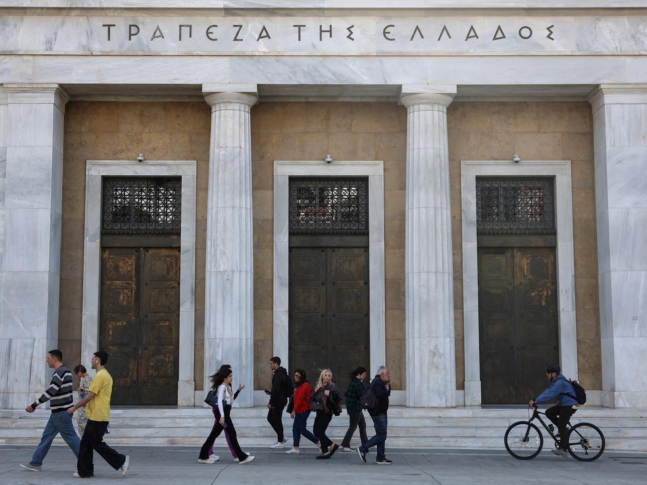 People walk past the Bank of Greece in central Athens.