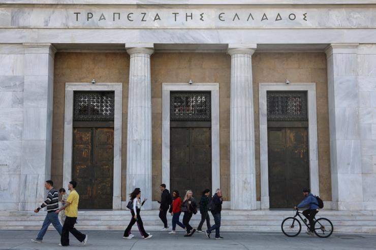People walk past the Bank of Greece in central Athens.