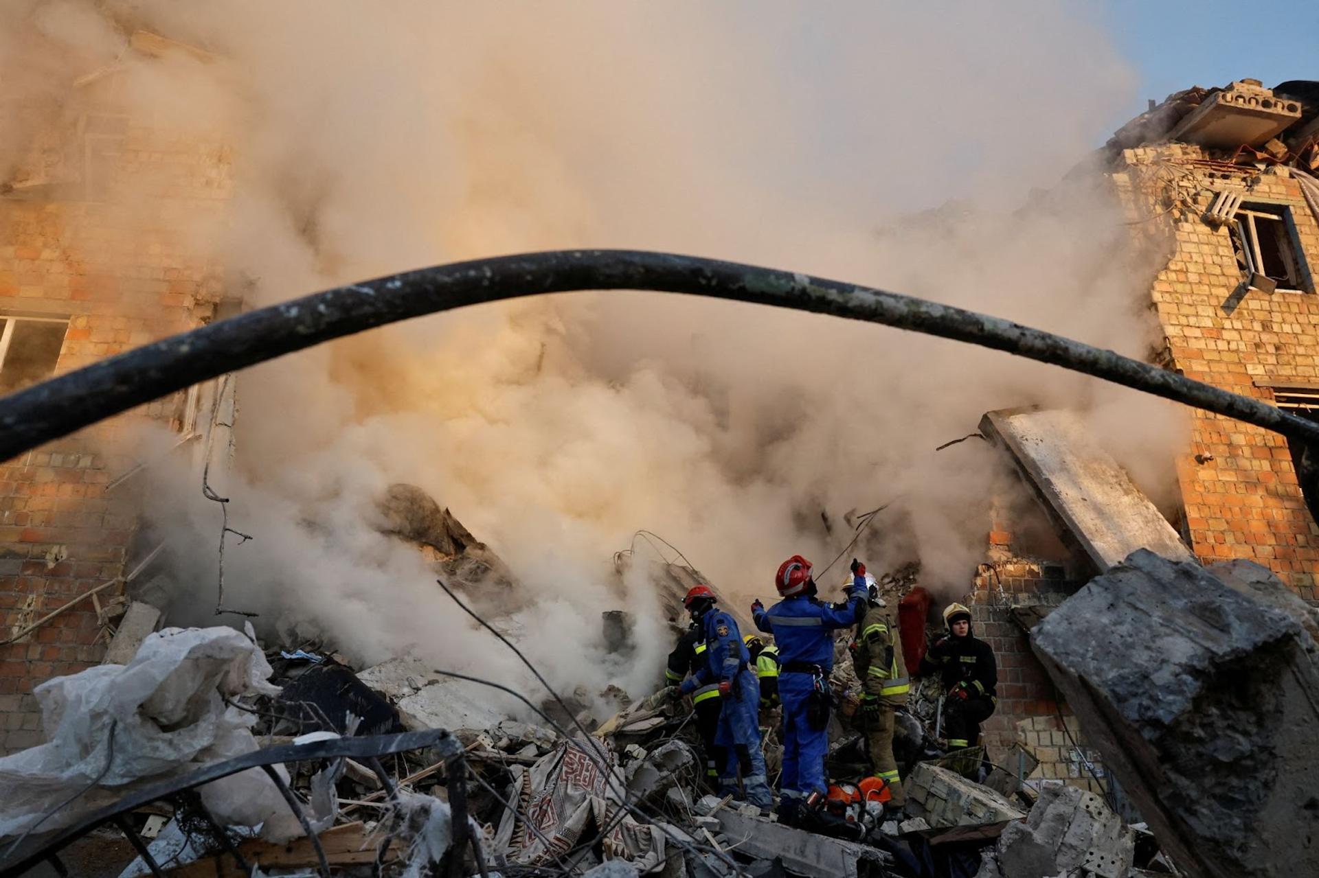 Rescuers work at the site of a building which was hit by Russian missile and drone strikes.