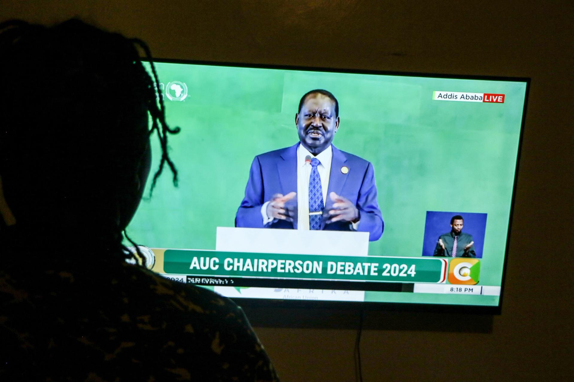 A person watches former Kenyan Prime Minister Raila Odinga speak during a televised debate for the African Union Commission Chairperson election.