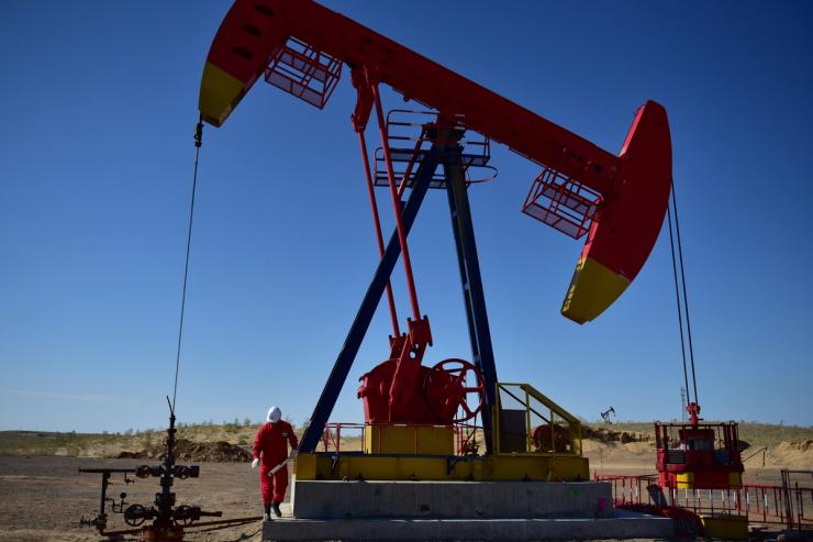 A PetroChina worker inspects a pump jack in Xinjiang Uighur Autonomous Region, China