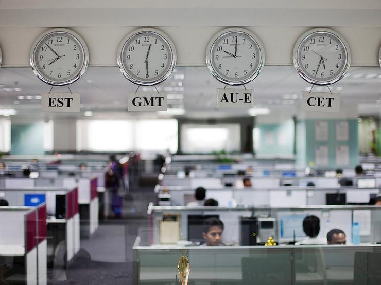 Workers are pictured beneath clocks displaying time zones in various parts of the world at an outsourcing centre in Bangalore.