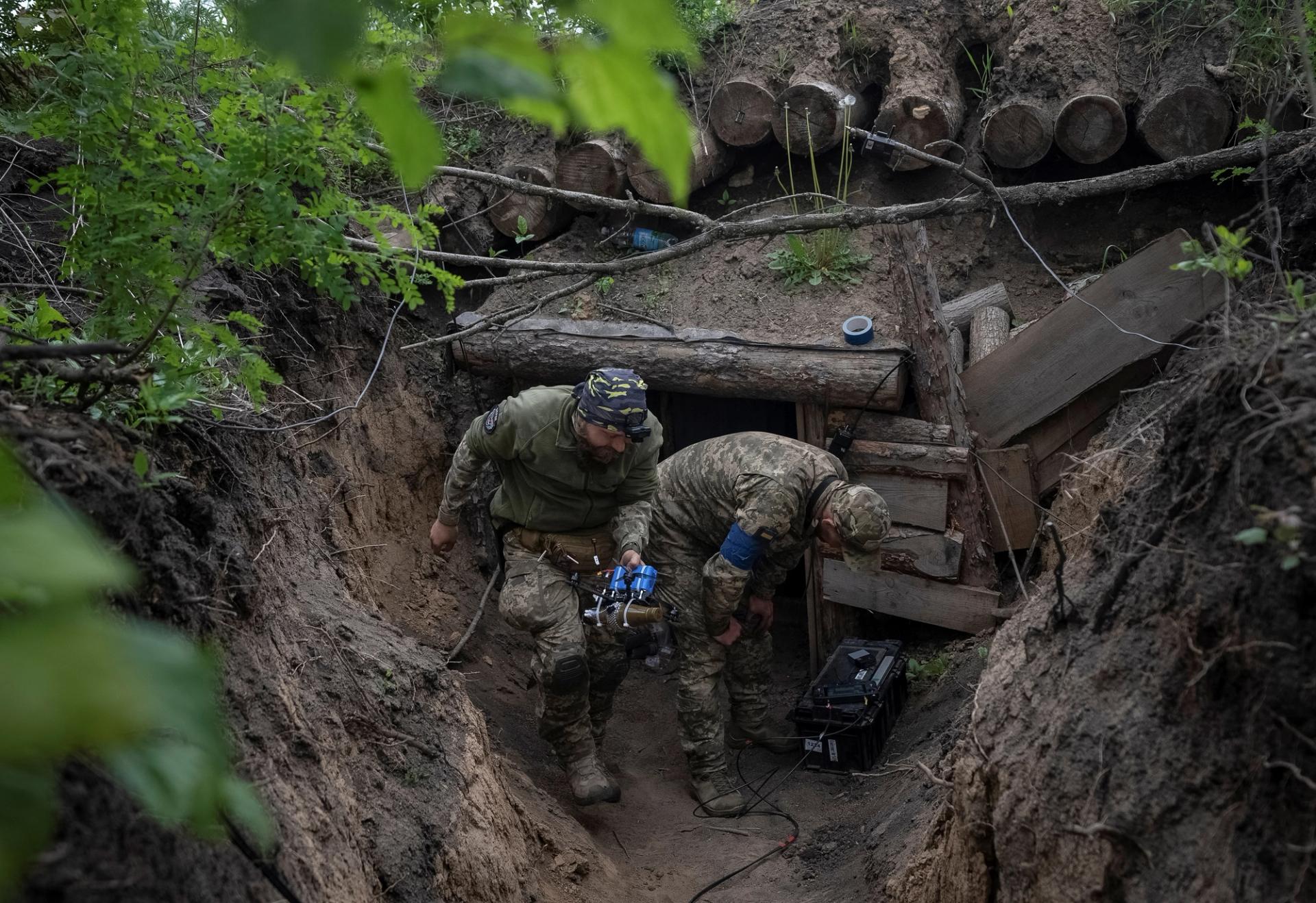 A Ukrainian serviceman of the attack drones battalion of the Achilles, 92nd brigade carries a first-person view (FPV) drone before it flies, near a Russian border in a Kharkiv region, Ukraine May 15, 2024. REUTERS/Inna Varenytsia