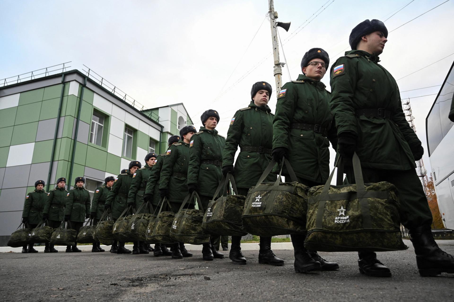 Russian conscripts called up for military service walk towards a bus before their departure for garrisons.