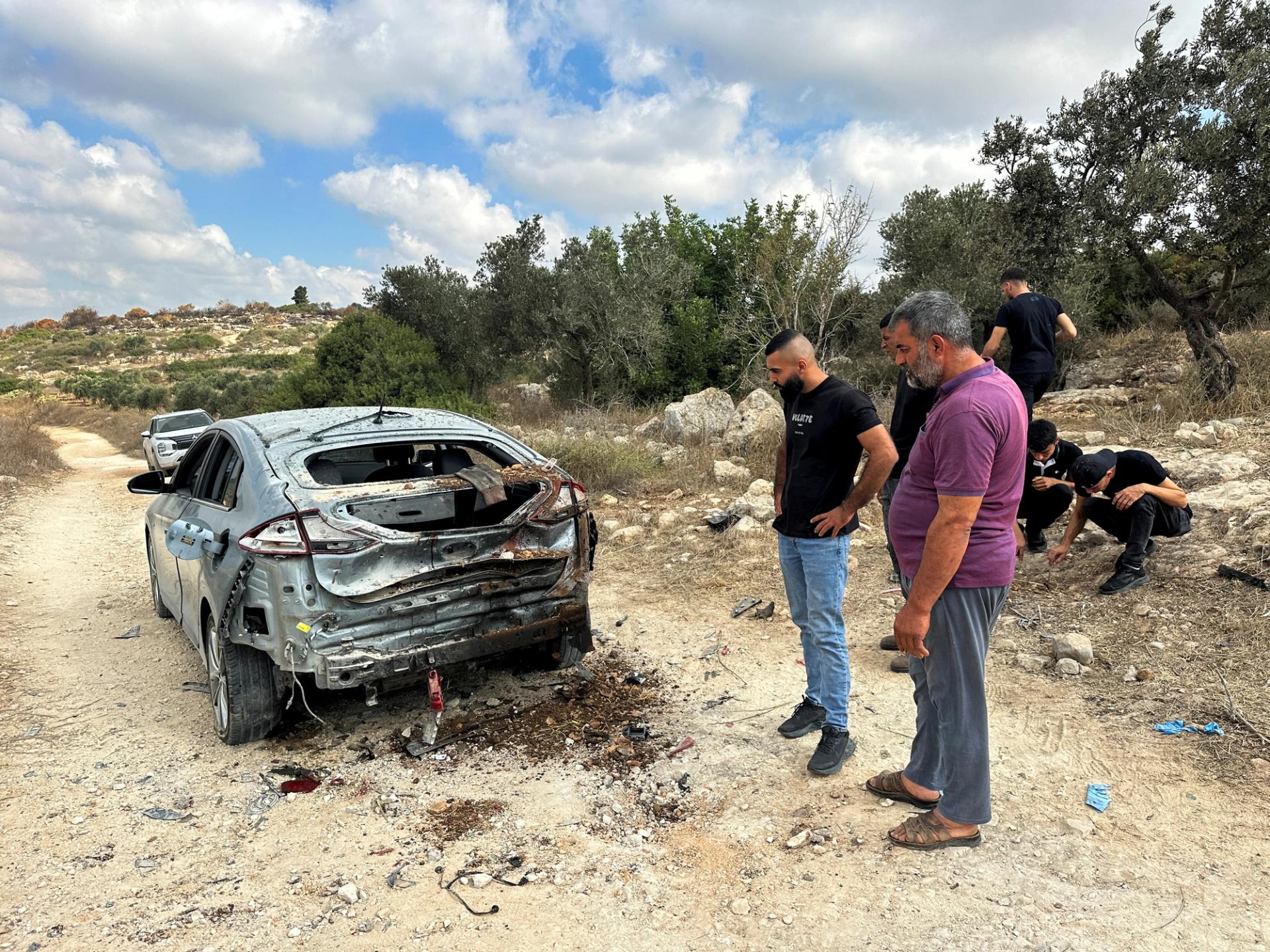 Palestinians assess the damage of a car during a military operation by Israeli forces near Jenin in the Israeli-occupied West Bank August 28, 2024. REUTERS/Ali Sawafta