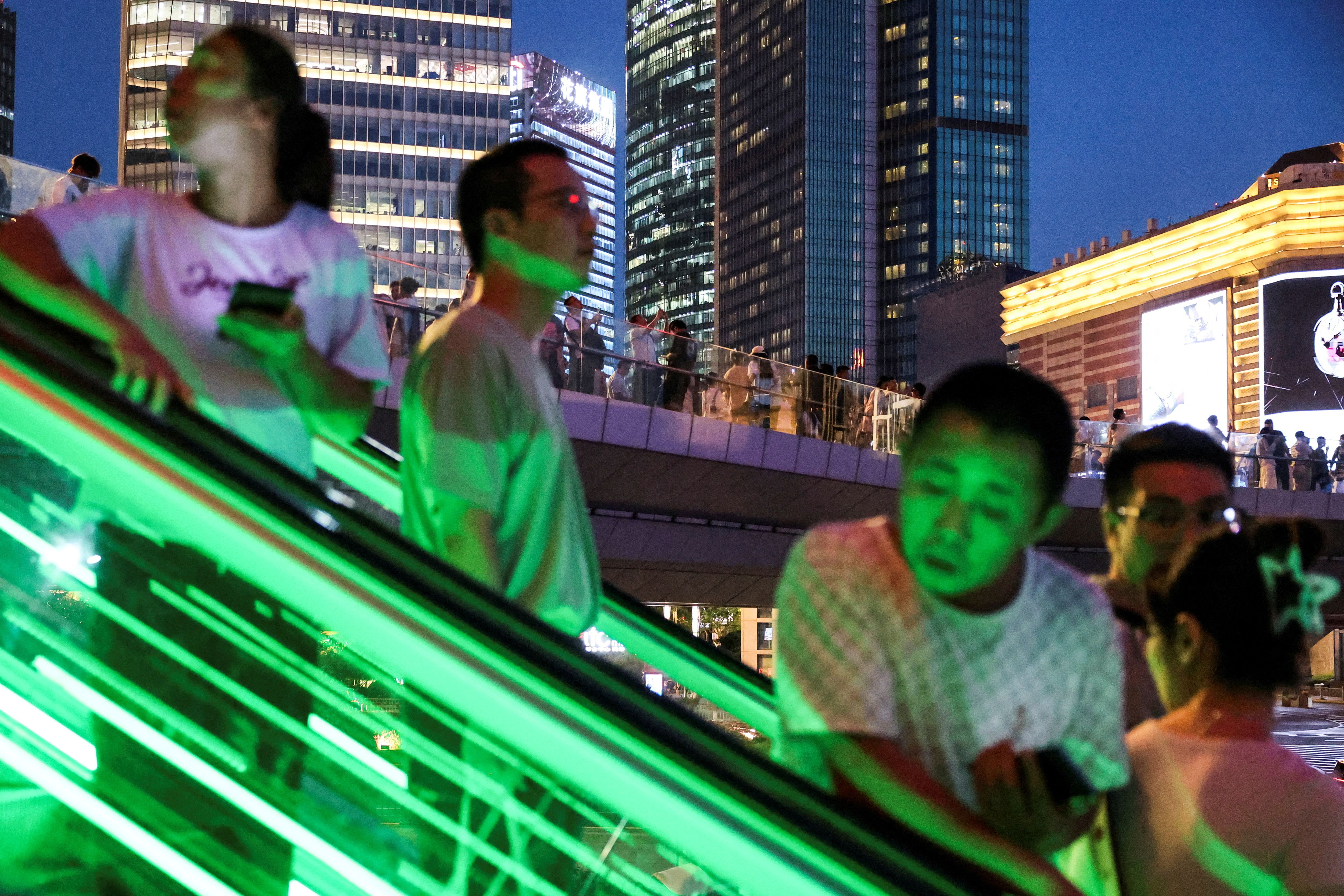 People ride an escalator at Lujiazui financial district in Shanghai.