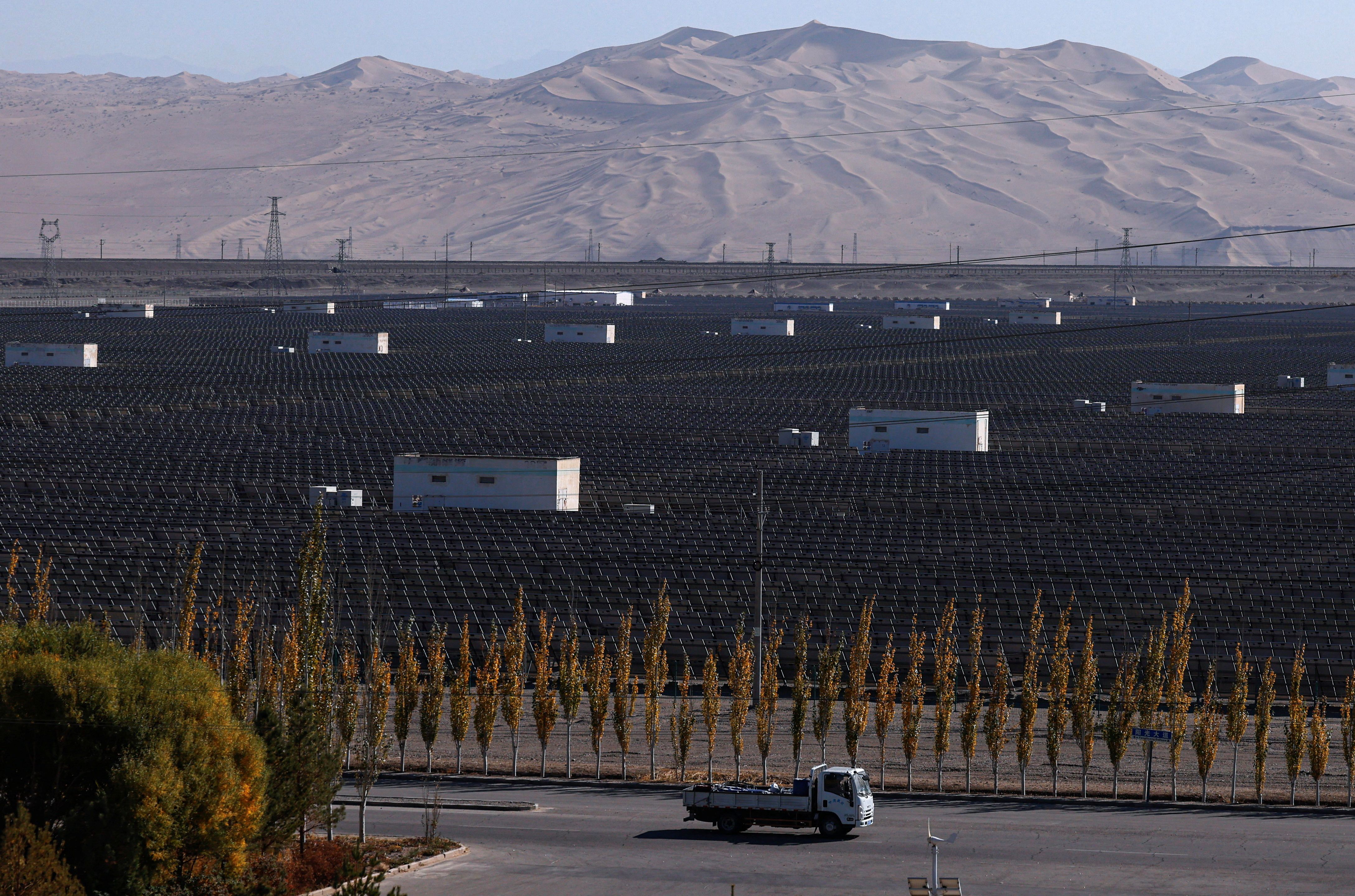A truck moves past solar panels at the Dunhuang Photovoltaic Industrial Park.