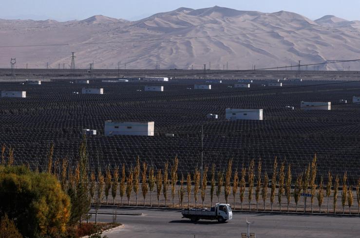 A truck moves past solar panels at the Dunhuang Photovoltaic Industrial Park.