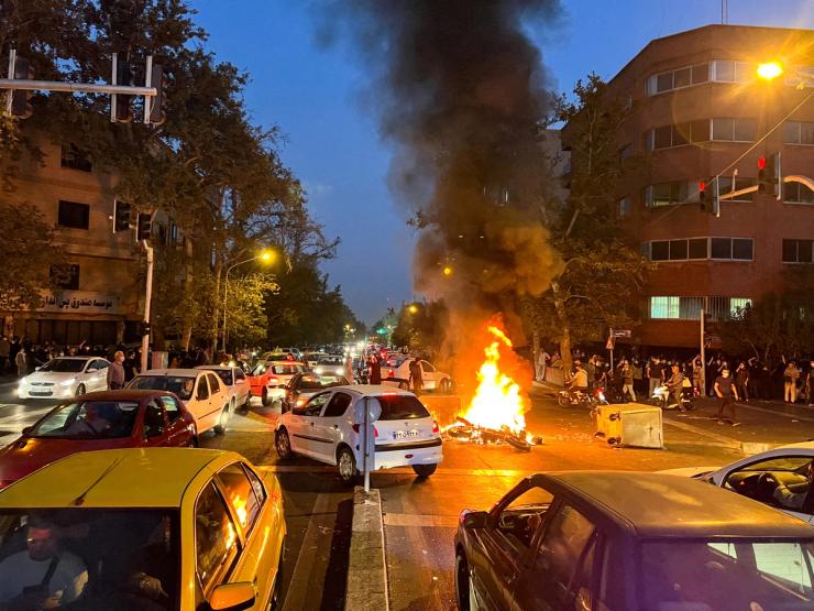 A police motorcycle burns during a protest over the death of Mahsa Amini, a woman who died after being arrested by the Islamic republic’s “morality police”, in Tehran, Iran.