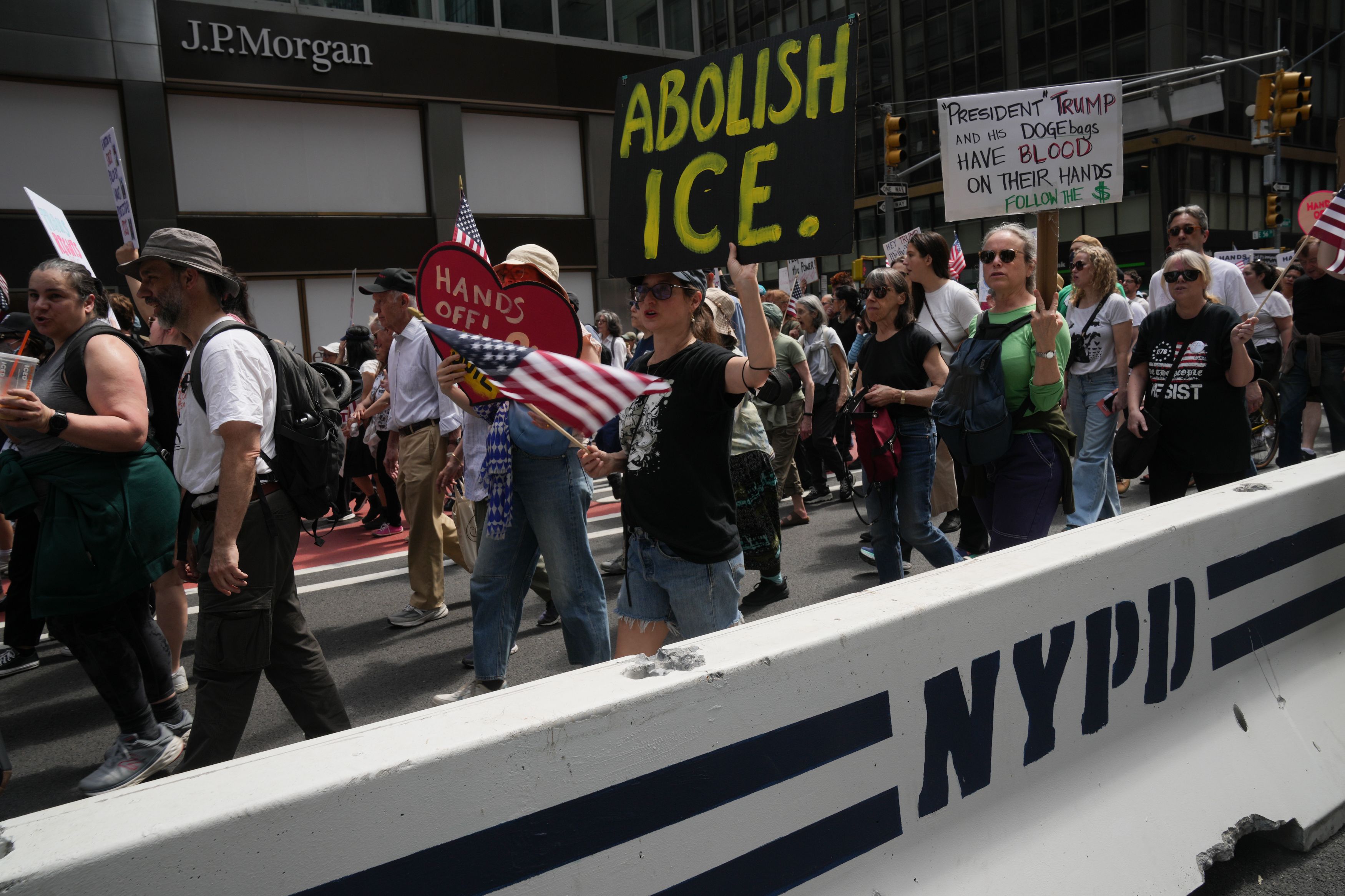 Protesters at an Earth Day event, including an “Abolish ICE” sign