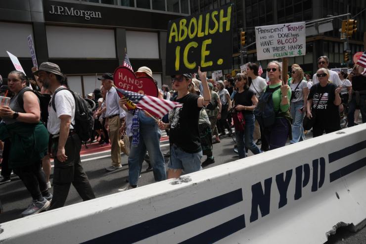 Protesters at an Earth Day event, including an “Abolish ICE” sign