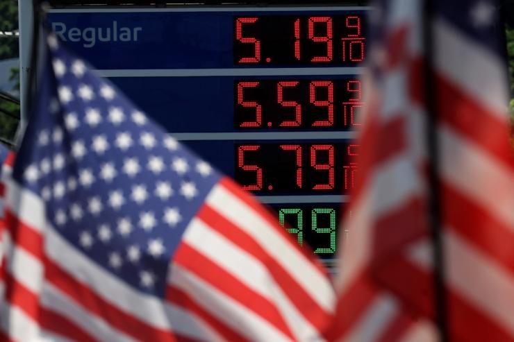 Gasoline prices are displayed at an Exxon gas station behind American flag in Edgewater, New Jersey
