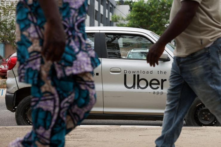 People walk past an Uber car as in Lagos, Nigeria, March 18, 2026.