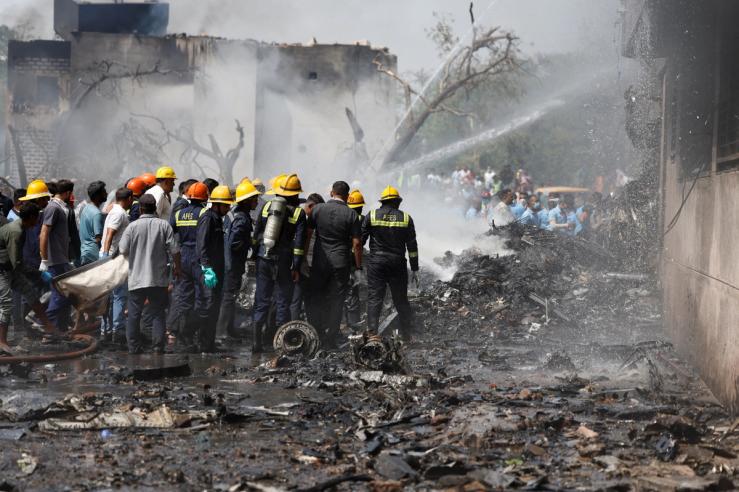 Firefighters work to put out a fire at the site where an Air India Boeing 787 Dreamliner plane crashed in Ahmedabad, India.