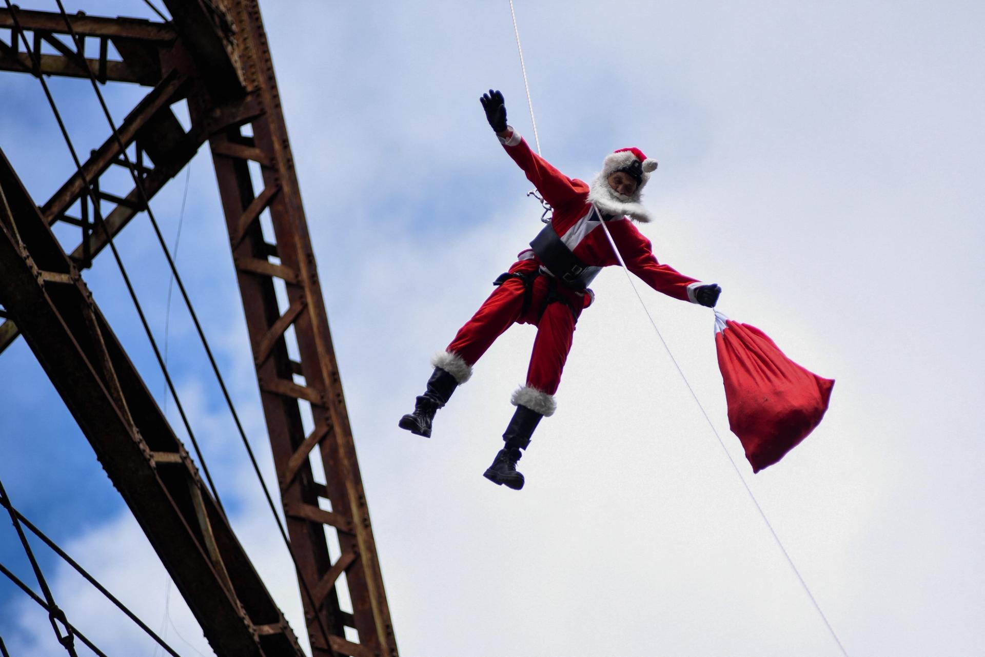 Guatemalan firefighter Hector Chacon, dressed as Santa Claus, rappels down the Belize Bridge to give toys to children at the Jesus de la Buena Esperanza neighbourhood, in Guatemala City, Guatemala, December 17, 2023.