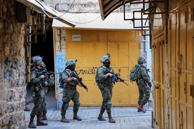Israeli troops walk during a weekly settlers’ tour in Hebron.