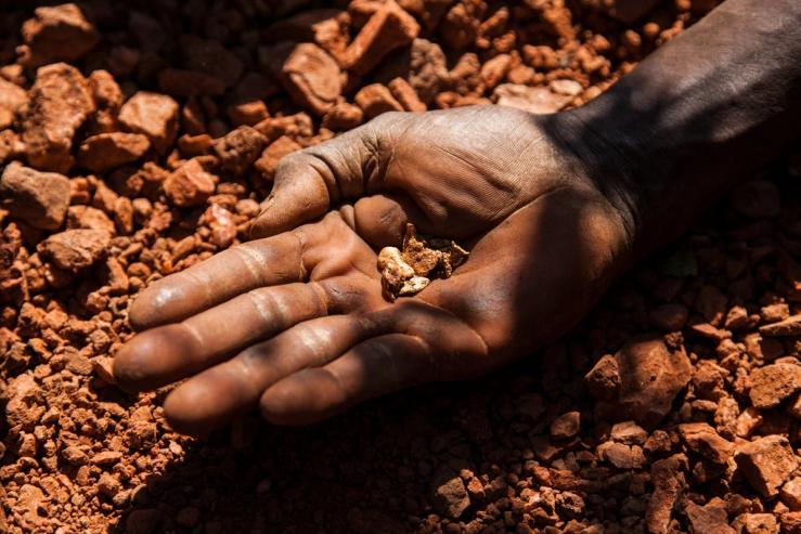 An artisan miner displays raw gold nuggets at an excavation site in South Sudan.
