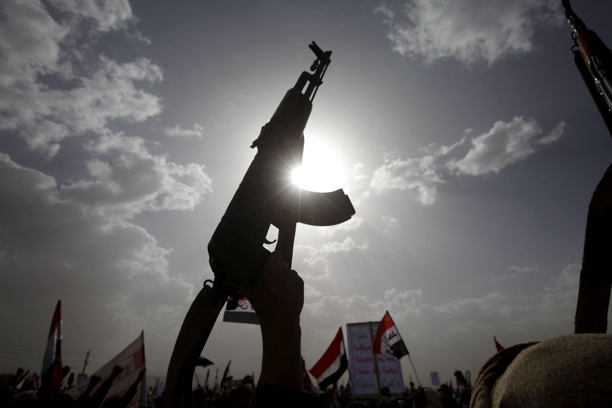 A Houthi follower rises a weapon as he attends a rally marking one year of Saudi-led air strikes, in Yemen’s capital Sanaa
