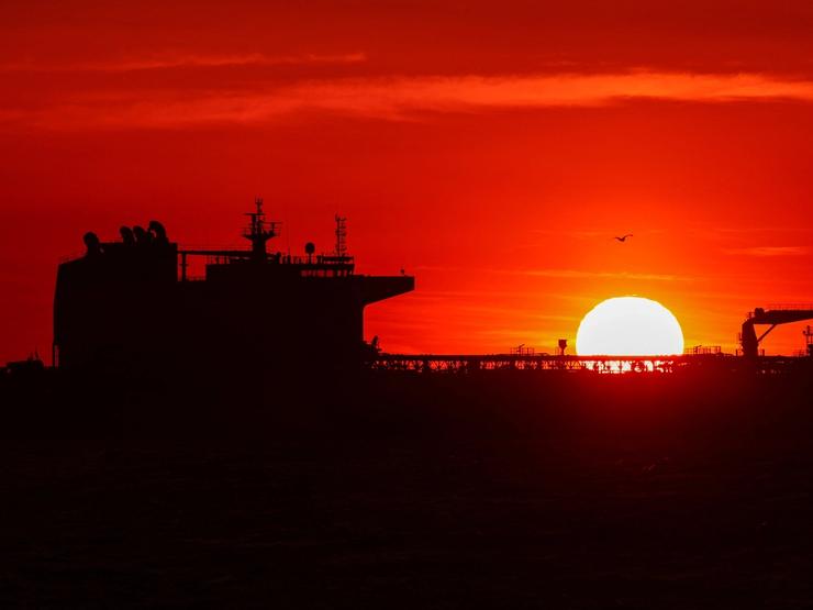 An oil tanker anchors near the oil hub of the port of Fos-Lavera at sunset near Marseille.