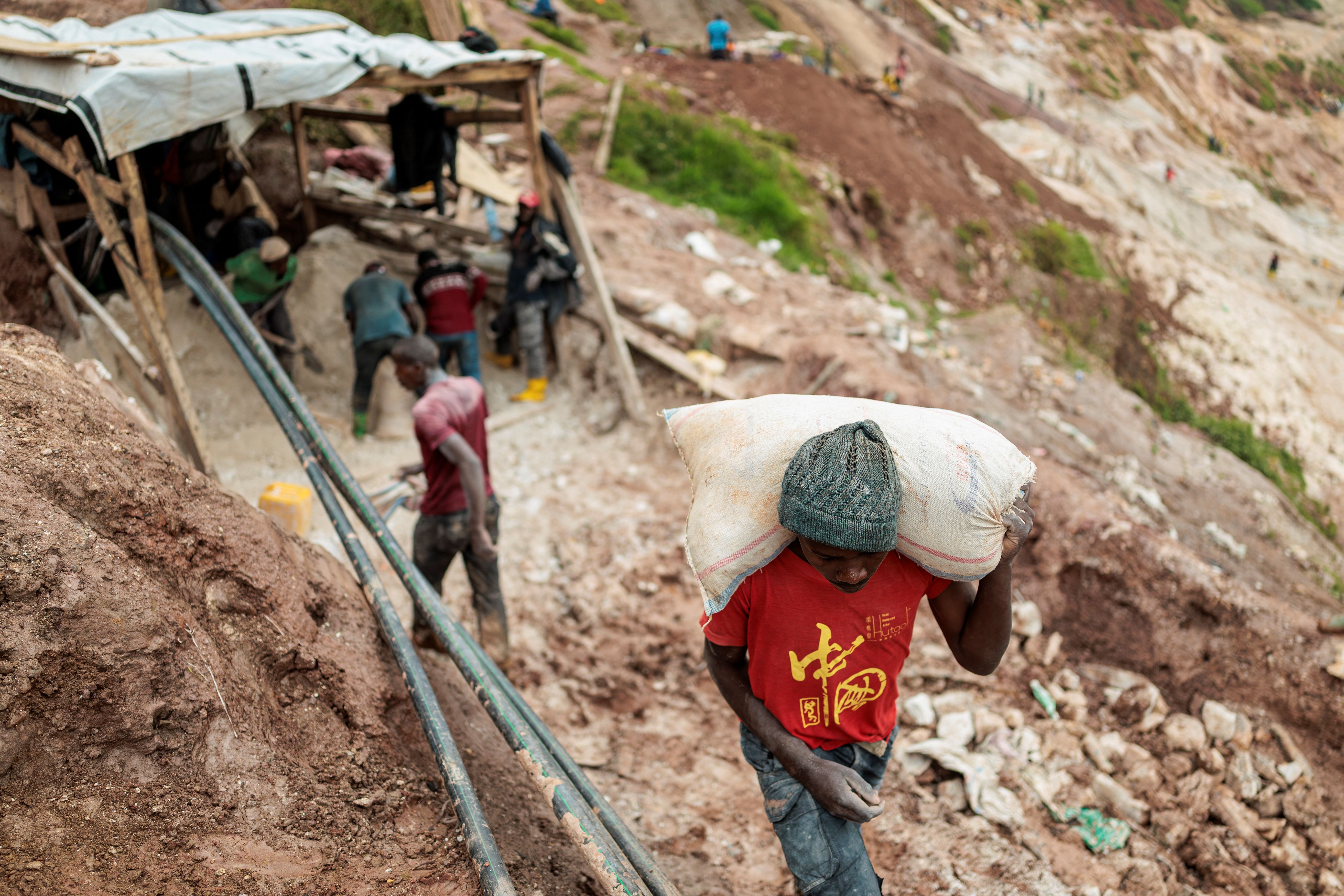 A laborer carries a sack of ore at the Rubaya coltan mine.