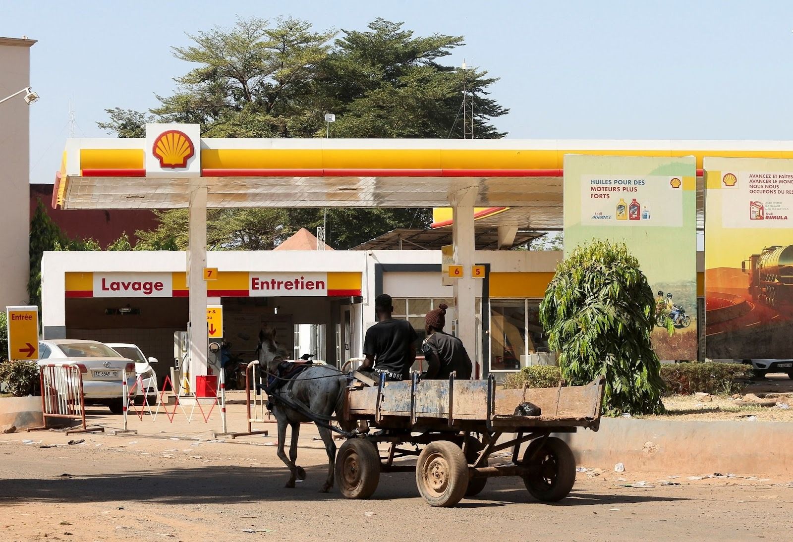 A horse pulling a cart in front of a gas station in Bamako. 