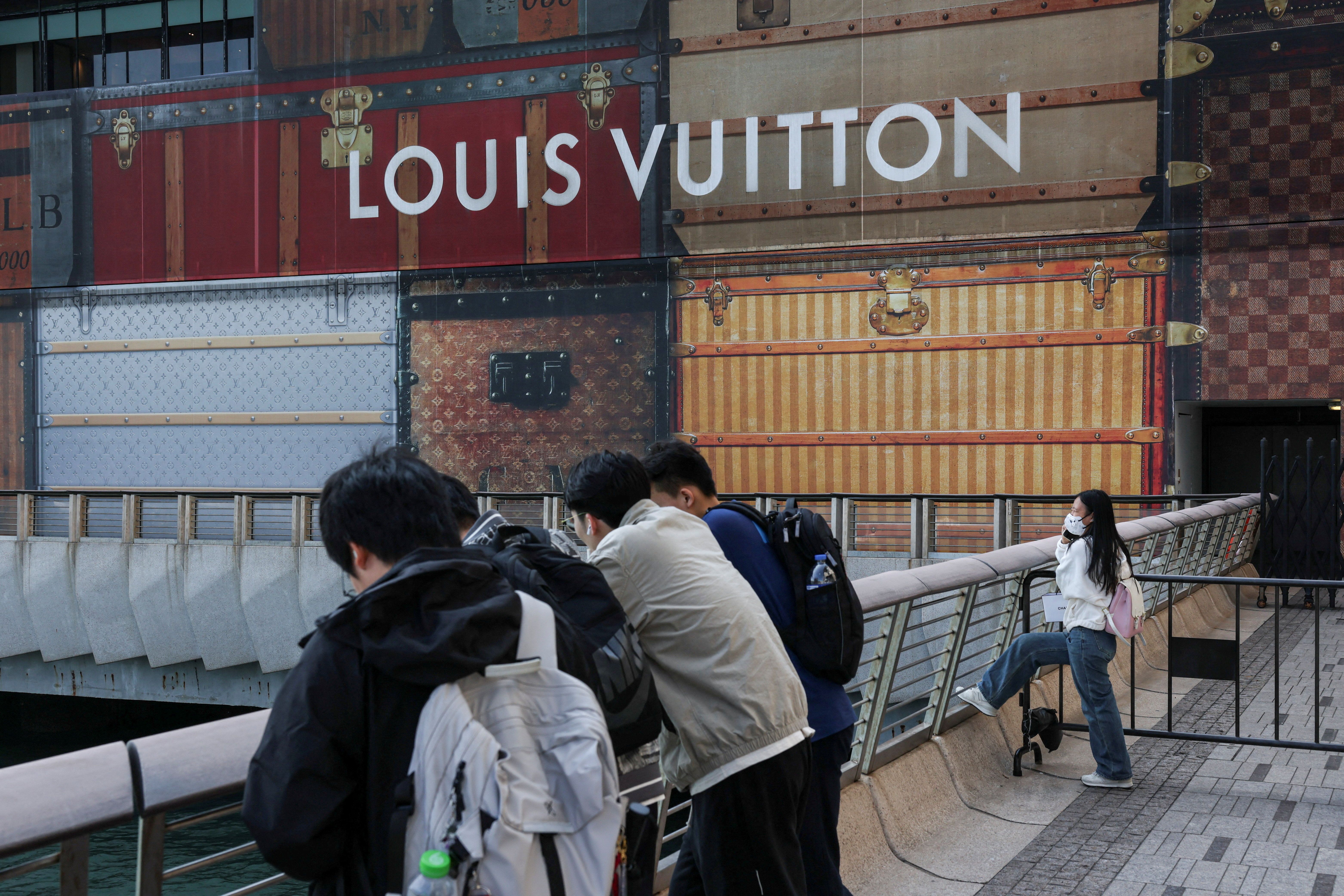 Tourists rest outside a Louis Vuitton store under renovation outside K11 MUSEA in Hong Kong