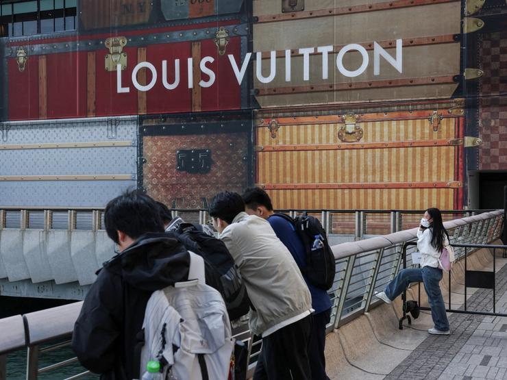 Tourists rest outside a Louis Vuitton store under renovation outside K11 MUSEA in Hong Kong