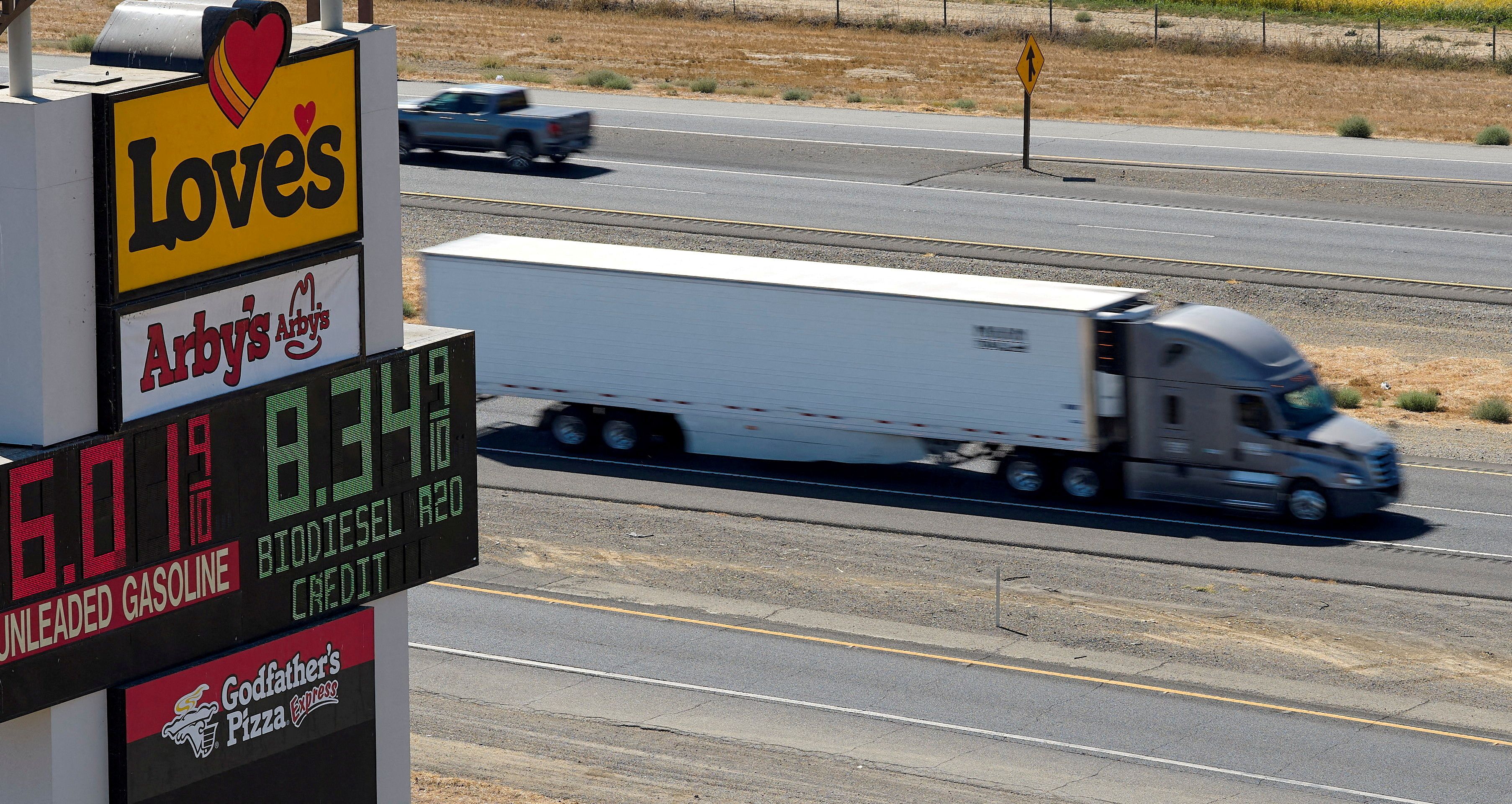 A photo showing a truck in the US next to a sign with gasoline and diesel prices. 