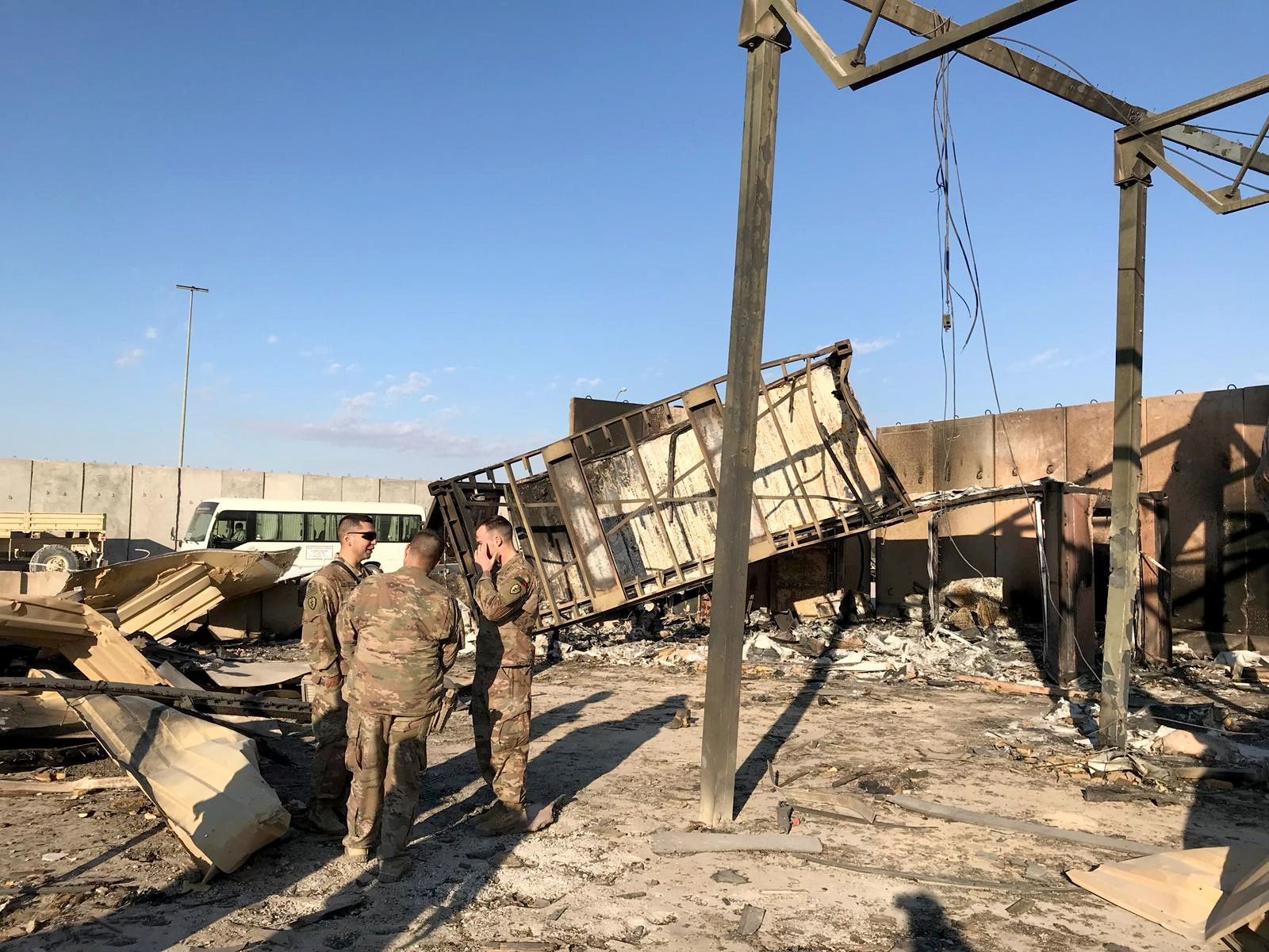 U.S. soldiers are seen at the site where an Iranian missile hit at Ain al-Asad air base in Anbar province in 2020