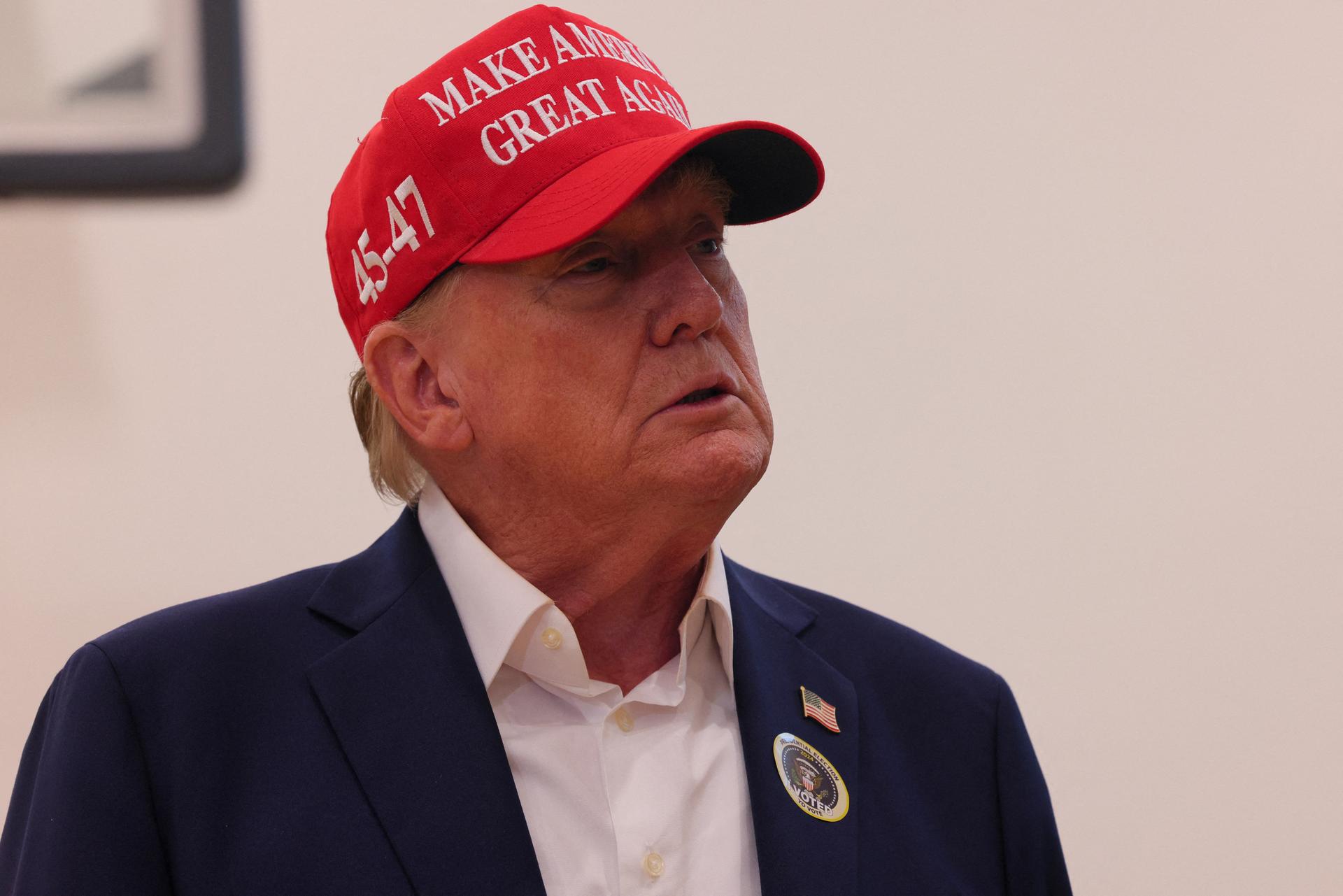 Republican presidential nominee and former US President Donald Trump wears an “I Voted” sticker as he speaks to reporters after voting at Mandel Recreation Center 