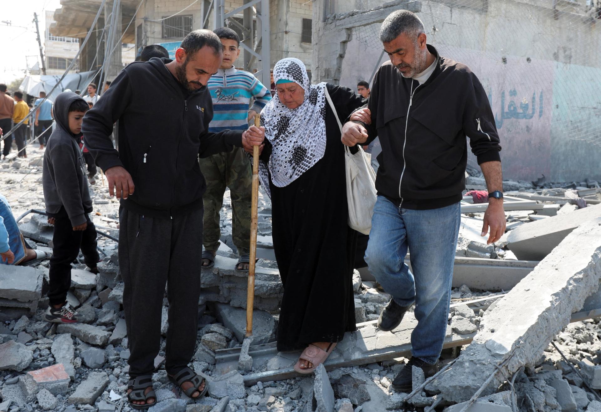 Palestinians walk at the site of an Israeli strike on a residential building, in Deir Al-Balah in the central Gaza Strip.