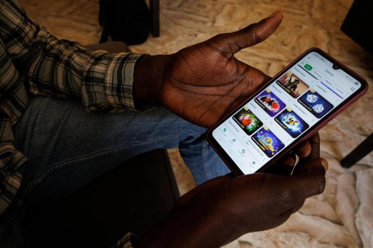 A man in Senegal holding a gambling app.