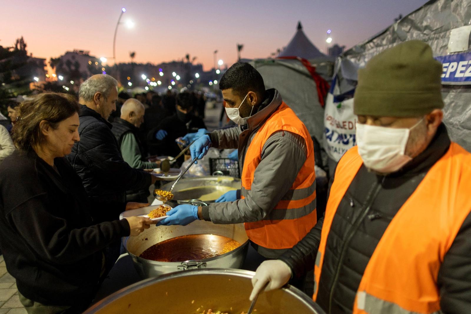 Volunteers serve food at a park turned into a camp for displaced people, following the deadly earthquake, in Iskenderun city, Hatay province, Turkey, February 14, 2023.