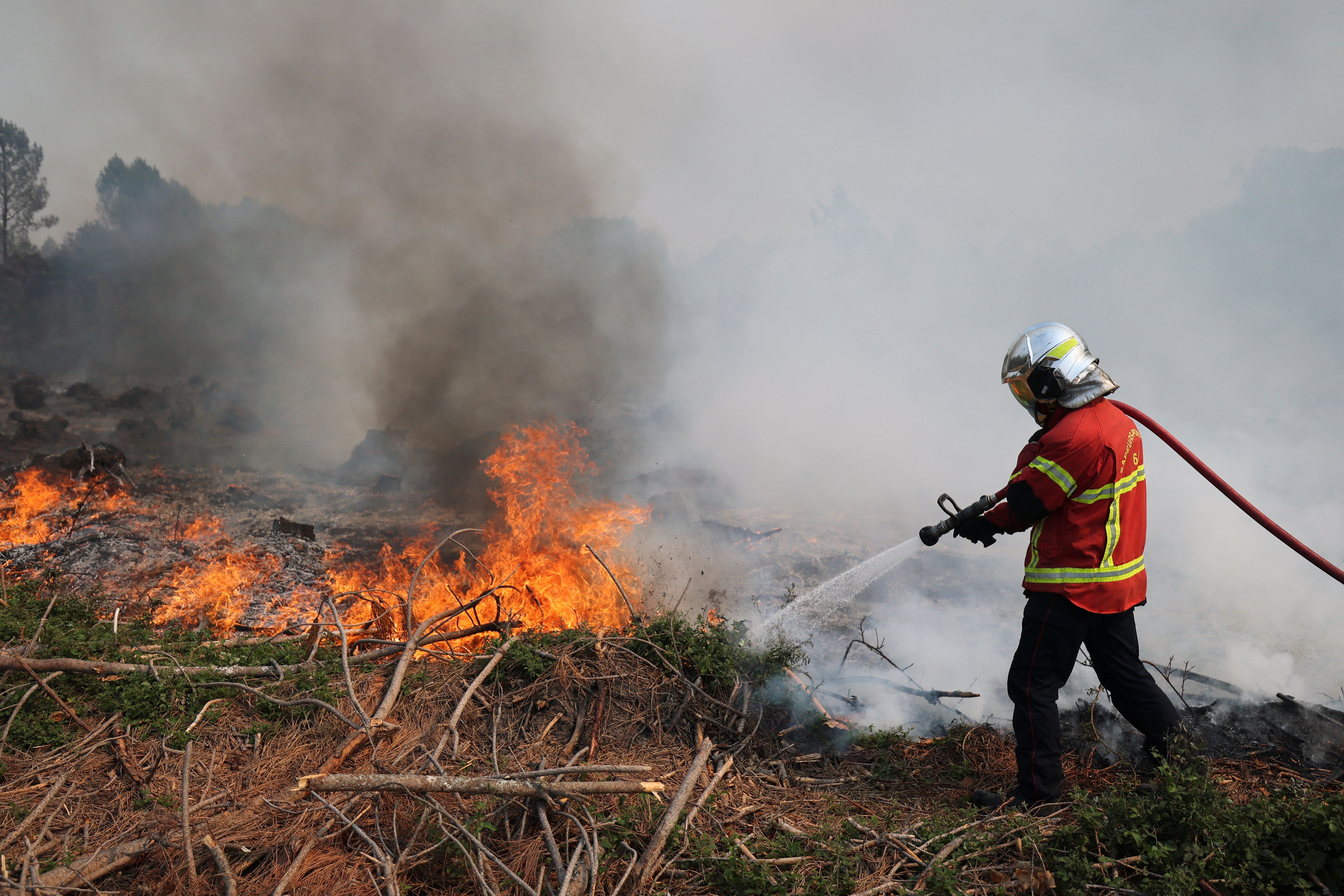 A firefighter tries to extinguish a wildfire in Luglon, France