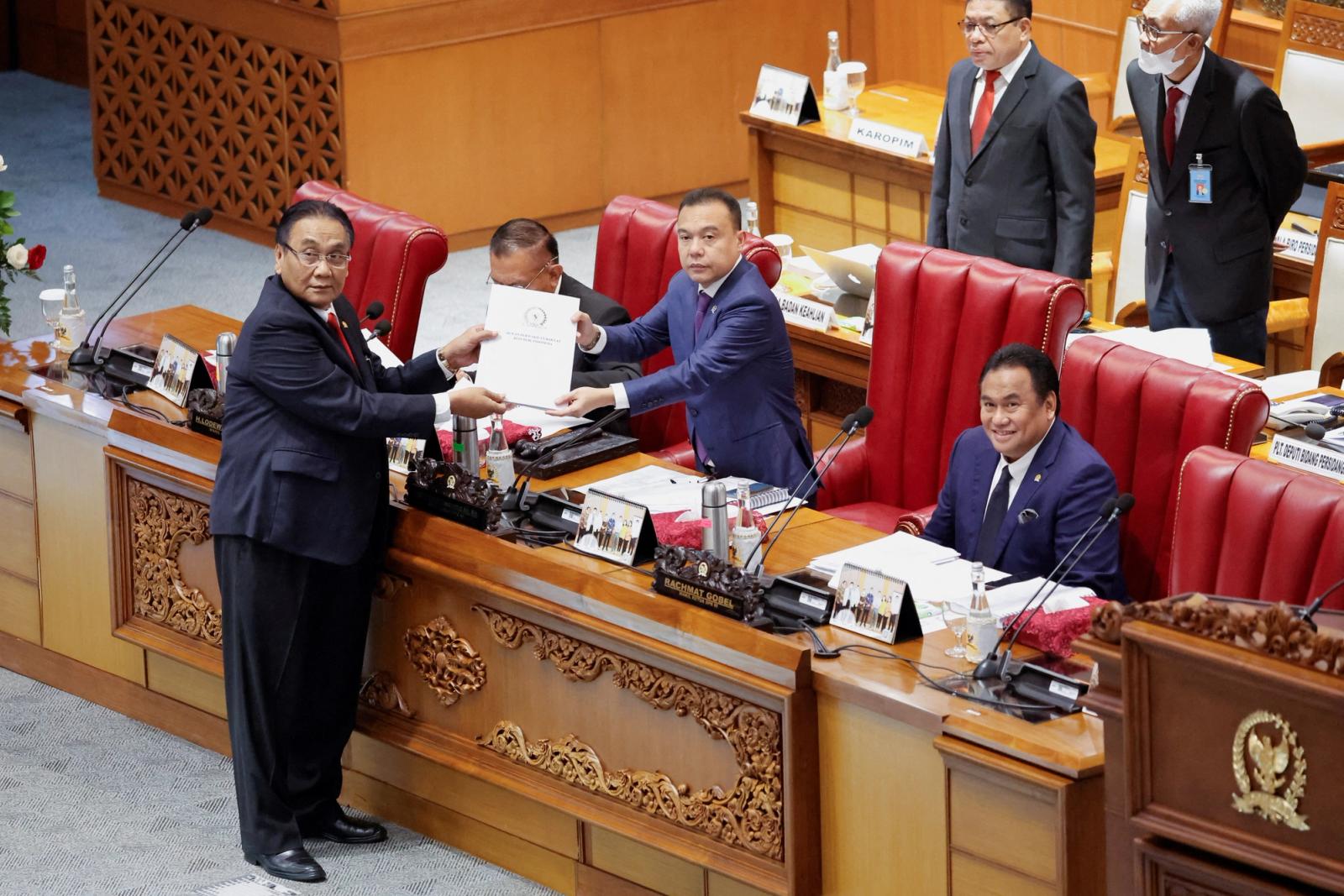 Bambang Wuryanto, head of the parliamentary commission overseeing the revision, passes the report of the new criminal code to Sufmi Dasco Ahmad, Deputy speaker of the House of Representatives, during a parliamentary plenary meeting in Jakarta, Indonesia