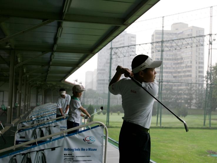 Young Chinese golf players practise at Chaoyang Kosaido Golf Club in Beijing.