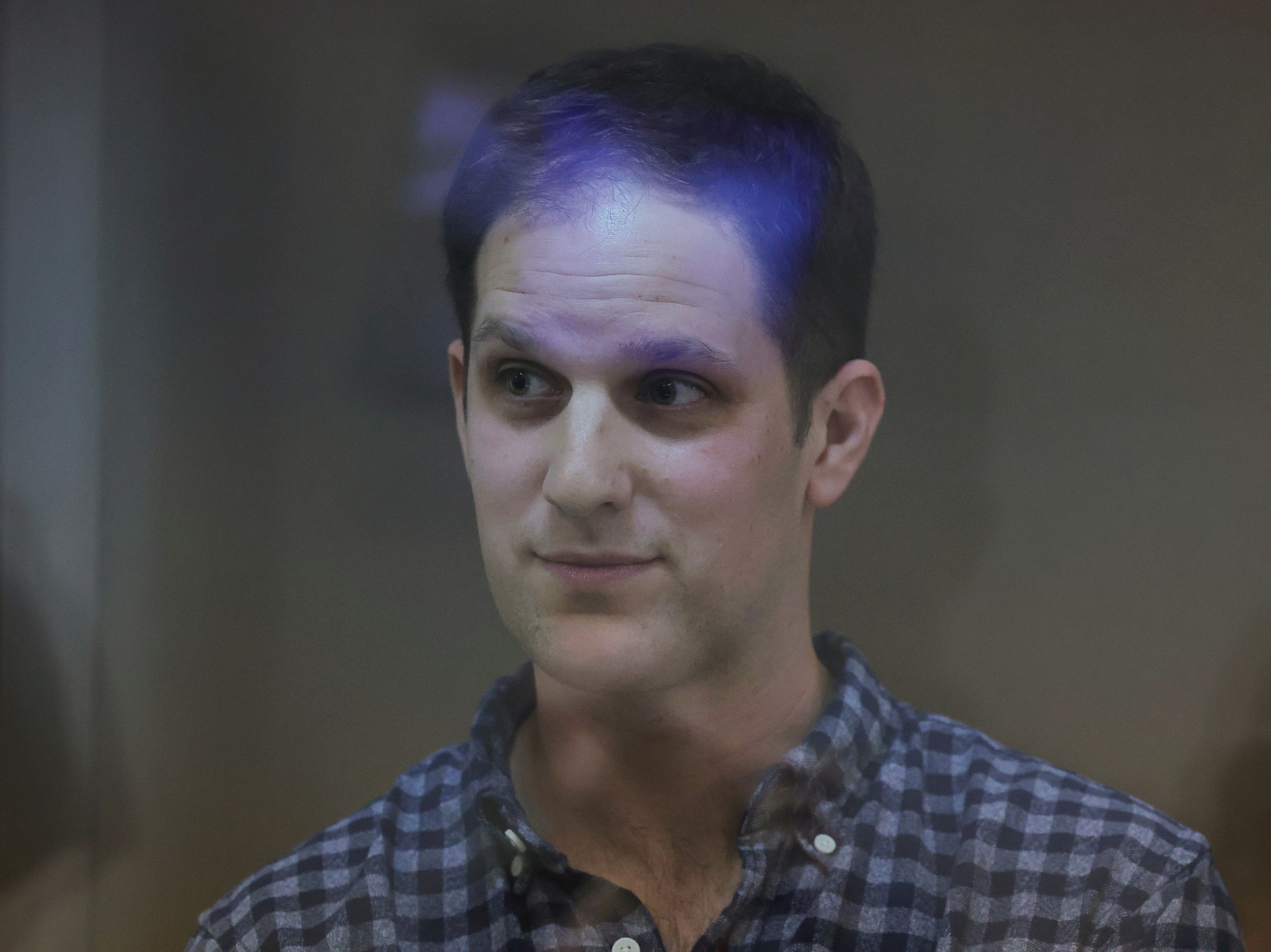 Wall Street Journal reporter Evan Gershkovich, who was detained in March while on a reporting trip and charged with espionage, stands behind a glass wall of an enclosure for defendants before a court hearing to consider an appeal against his detention, in Moscow, Russia April 18, 2023. REUTERS/Evgenia Novozhenina