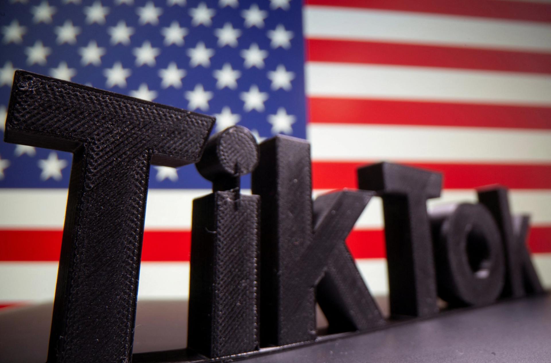 A 3D printed TikTok logo is seen in front of a US flag