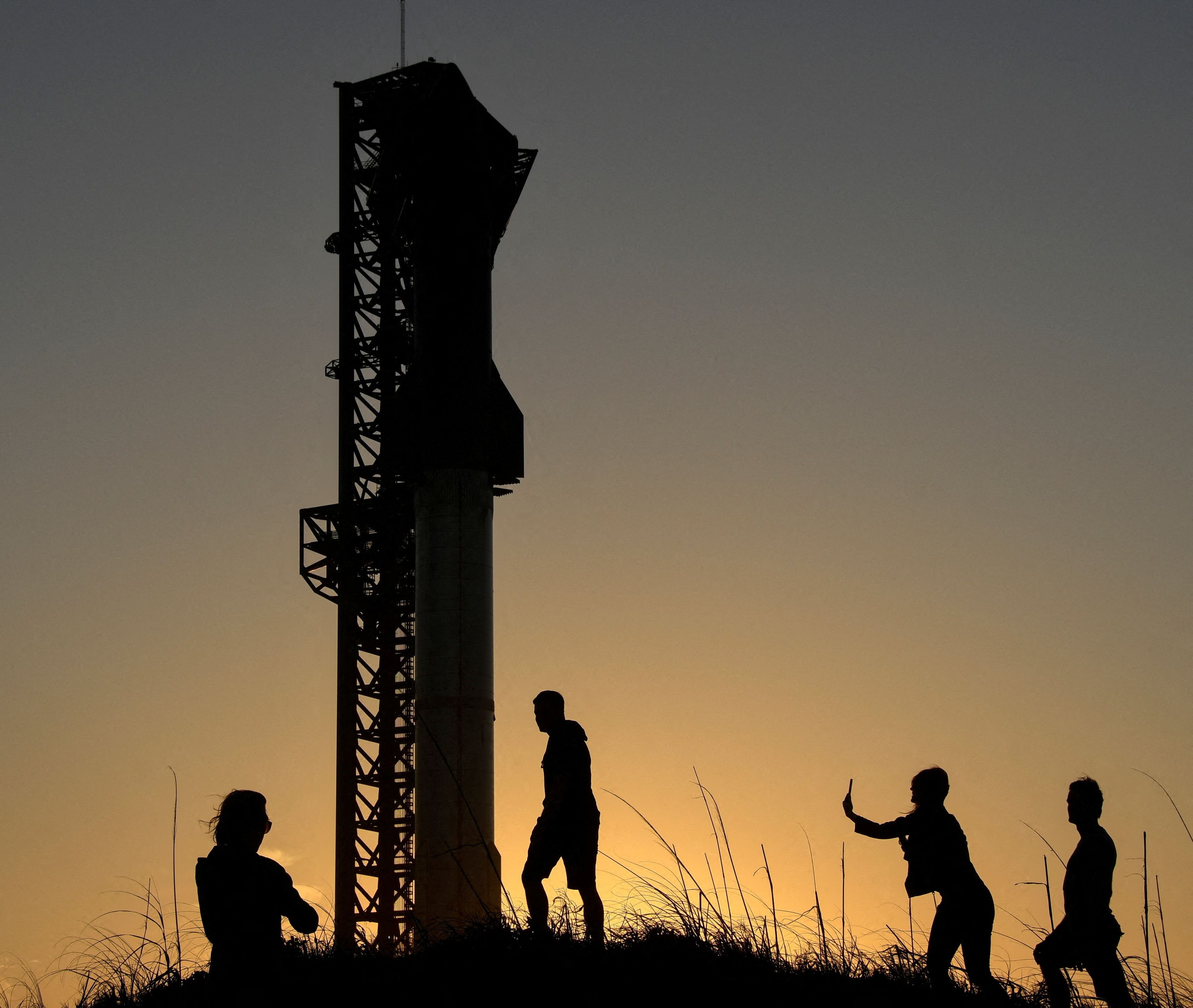 Tourists take photos at sunset of SpaceX’s Starship the day before it launches from the Starbase launchpad on an orbital test mission, in Boca Chica, Texas, U.S., April 16, 2023. REUTERS/Gene Blevins