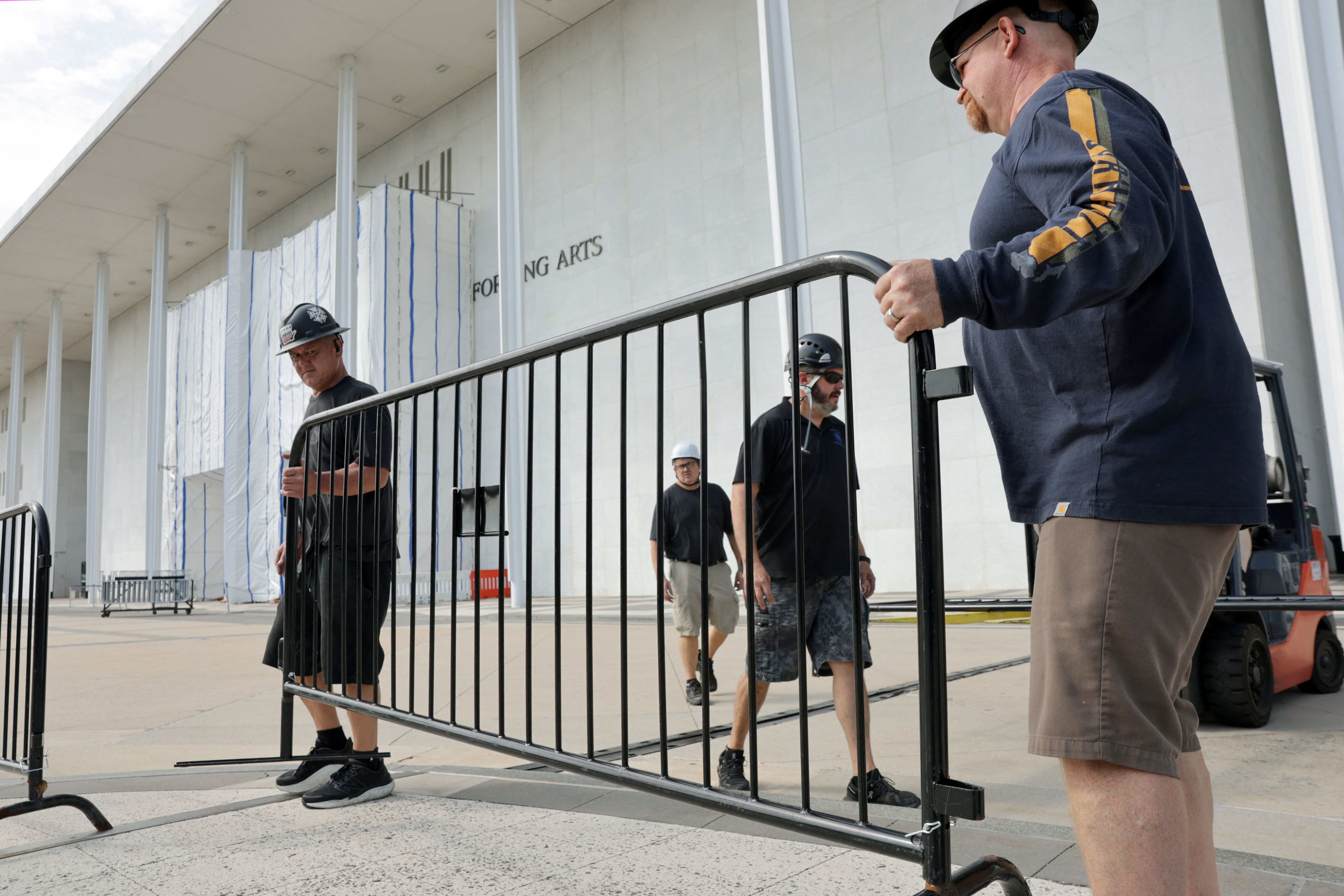 Workers replace parts of a temporary fence at the Kennedy Center