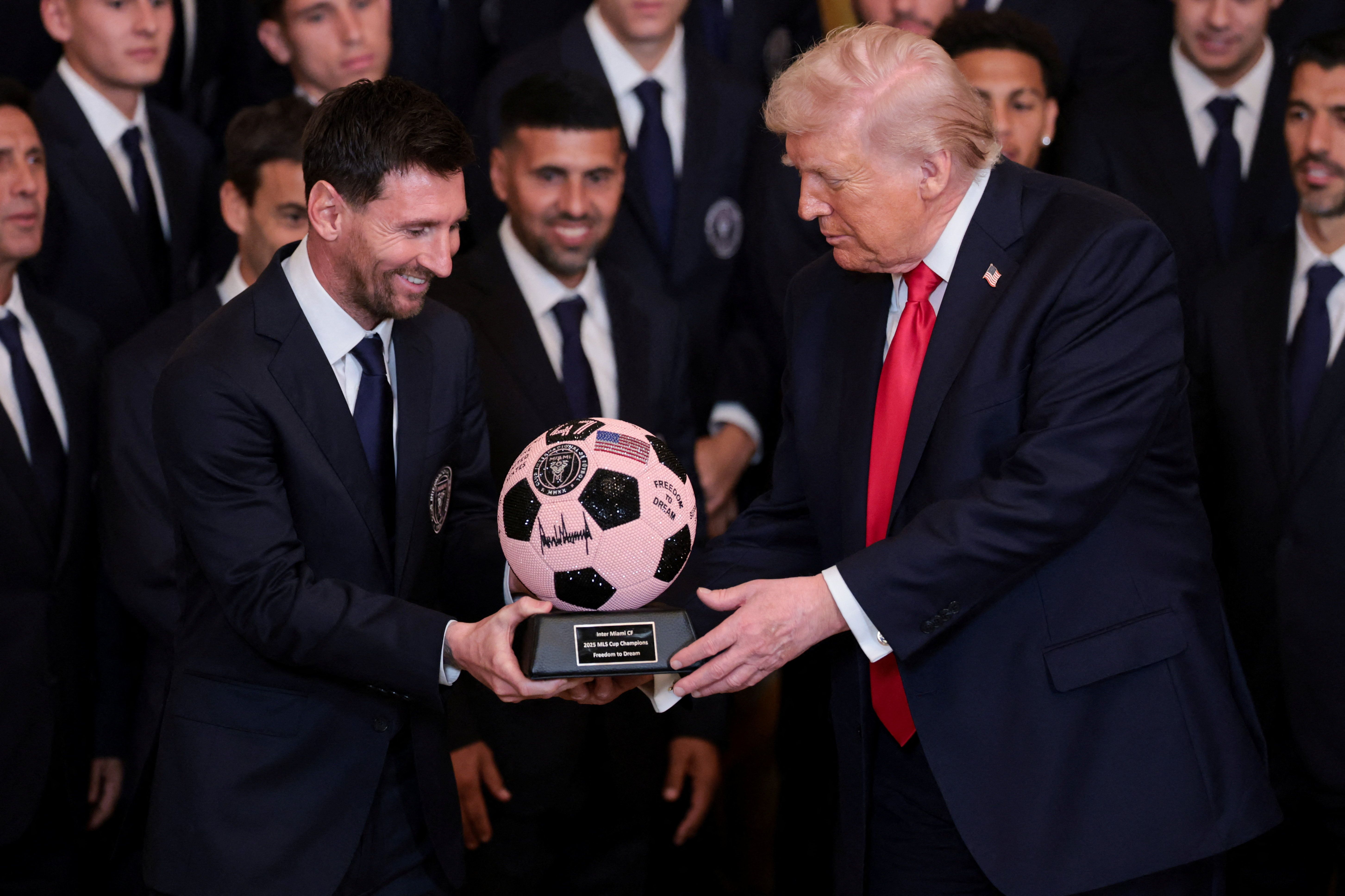 El ícono deportivo Lionel Messi le regala a Trump un balón de fútbol enjoyado en un evento de la Major League Soccer en la Casa Blanca.
