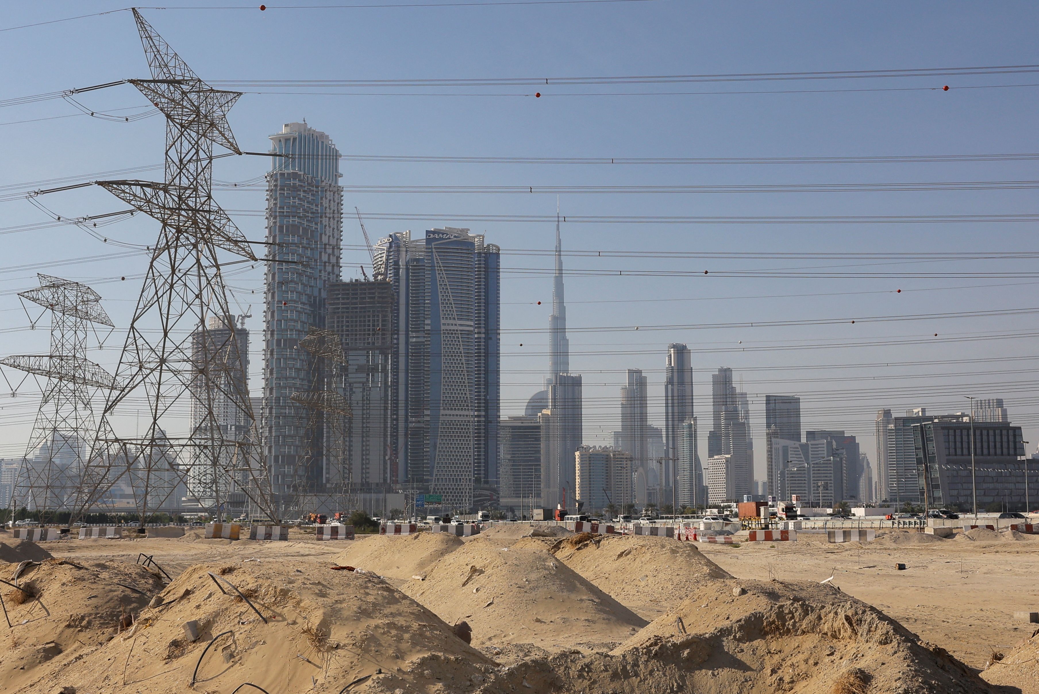 A construction site is seen, with the Dubai skyline in the background.