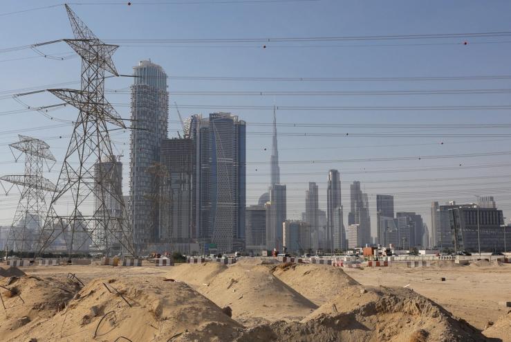 A construction site is seen, with the Dubai skyline in the background.