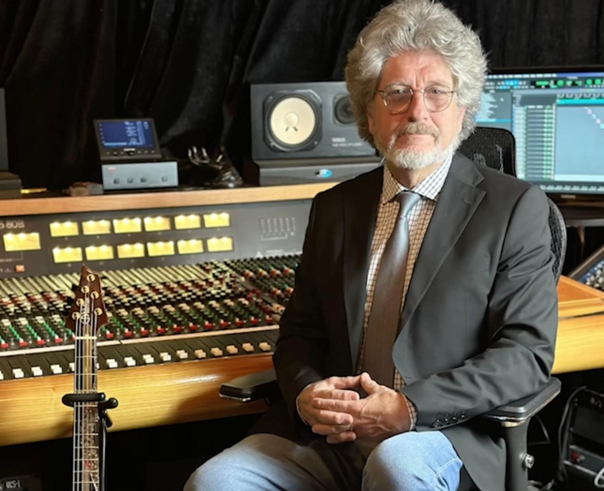 Randall Terry, a white, bearded man with long hair wearing a tie, blazer and blue jeans