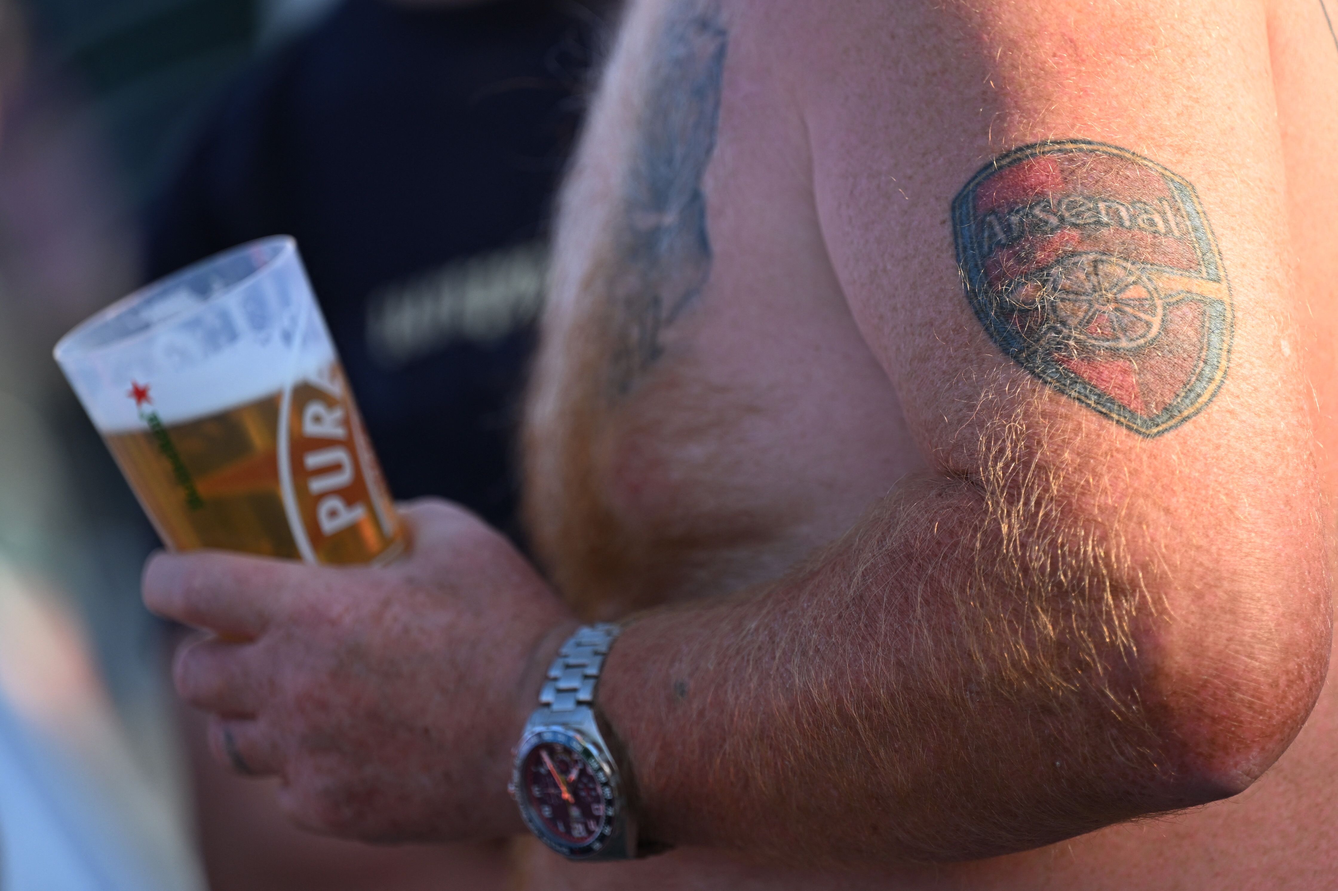 An Arsenal fan holding a beer