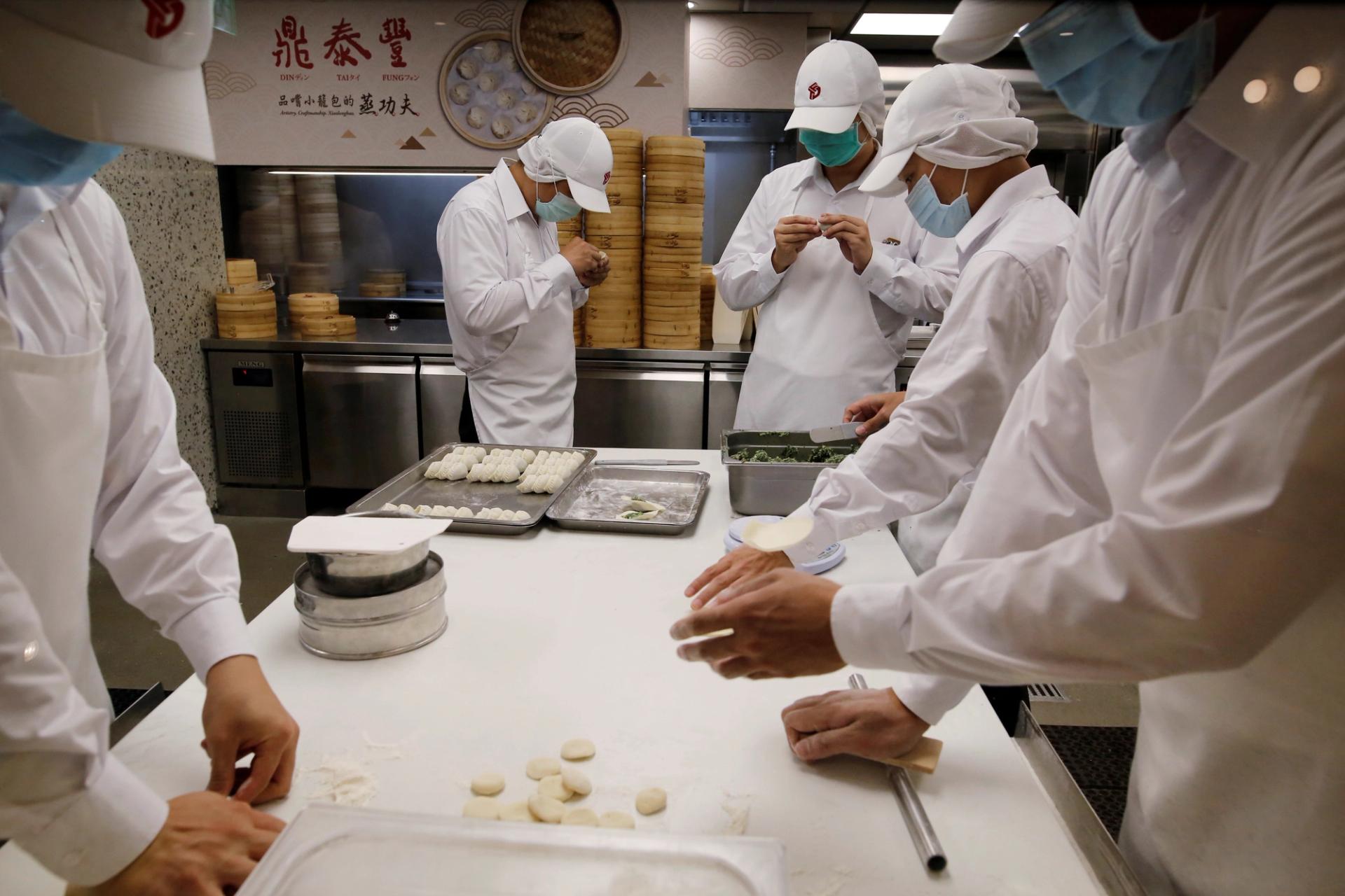 Chefs make dumplings in the kitchen of Din Tai Fung.